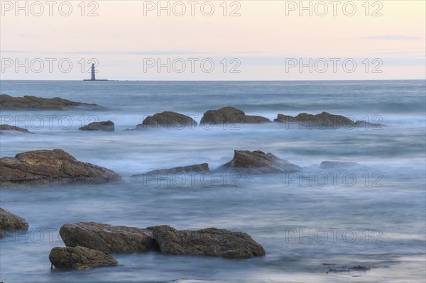 The lighthouse of the barges on the horizon seen from the beach of Sauveterre. Les Sables d'Olonne,