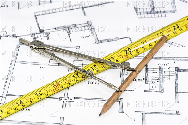 Compass calipers and pencil lying on construction plan