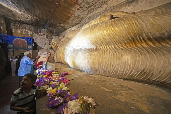 Pilgrims at the reclining Buddha in the Dambulla cave temple, Dambulla, Central Province, Sri