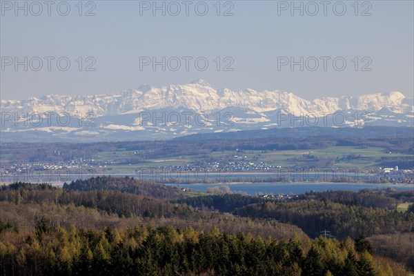 A wide landscape with a lake and snow-capped mountains of Säntis in the Alpstein in the background