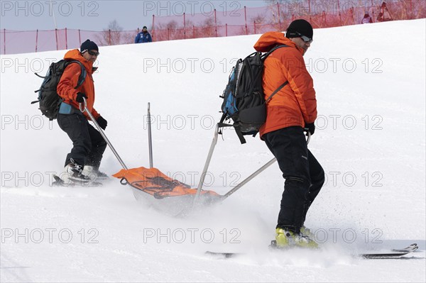 KAMCHATKA, RUSSIA, MARCH 28, 2019: Rescuers Kamchatka Rescue Squad on alpine ski with stretcher