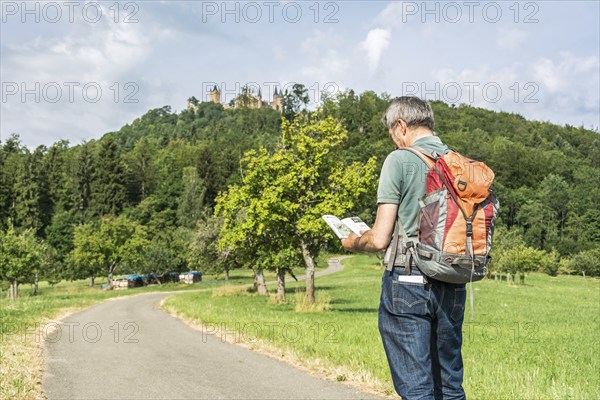 Male hiker looking at his hiking guidebook