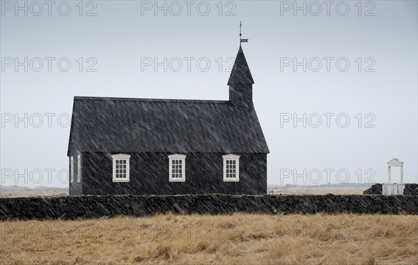 Famous picturesque black church of Budir at Snaefellsnes peninsula region in Iceland during a heavy