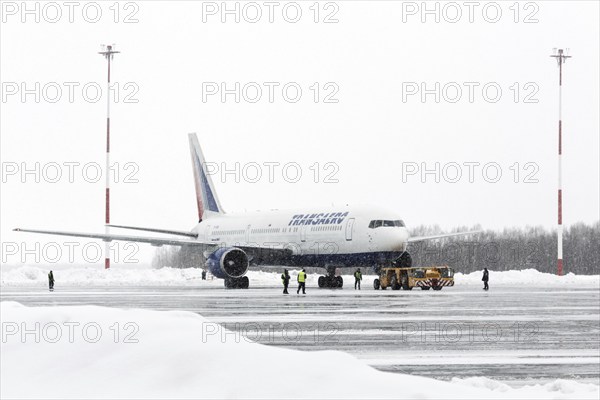 PETROPAVLOVSK-KAMCHATSKY, KAMCHATKA, RUSSIA, MARCH 19, 2015: Airdrome trucks pulling airplane