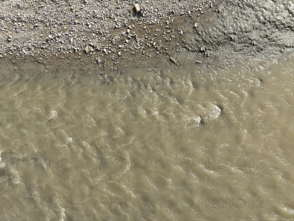 Muddy water is flowing in the arda river near mignano val tolla, piacenza, italy, creating a