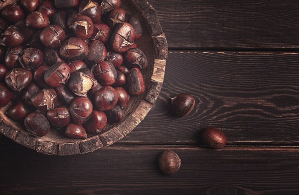 Roasted chestnuts, in a wooden plate, top view, homemade, no people