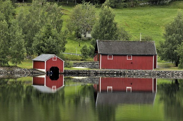 Red wooden boathouses at lake in Norway, Scandinavia