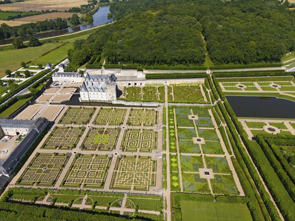 Aerial view of a castle with formal, geometric gardens consisting of labyrinths, ponds and