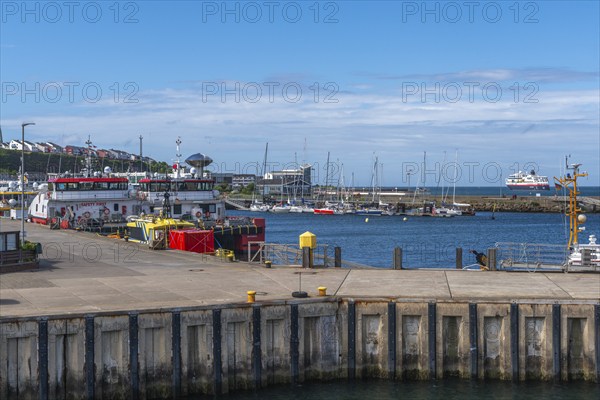 Inland harbour with sailing yachts and offshore supply ships, pier, passenger ship MS Maud of