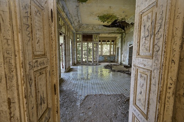 Abandoned building with large windows and dirty tiles, the dilapidated interior has clear signs of