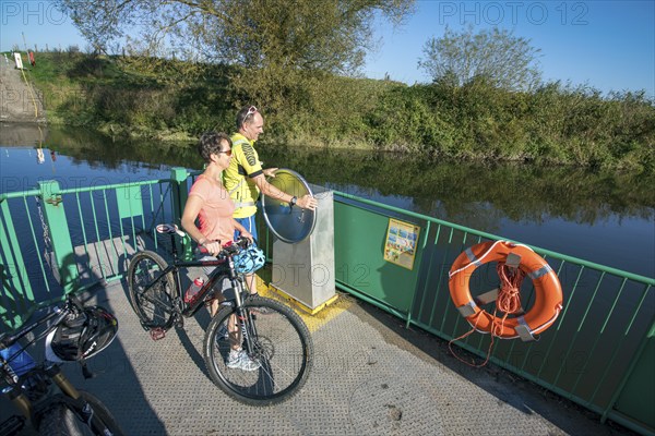 Cyclist, cycle tour, manually operated ferry across the Lippe near Halten am See, on the