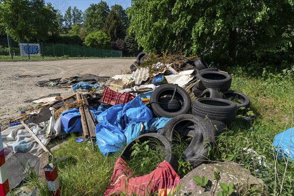 Illegally disposed waste, car tyres, building rubble, household waste, clothing, on a path next to