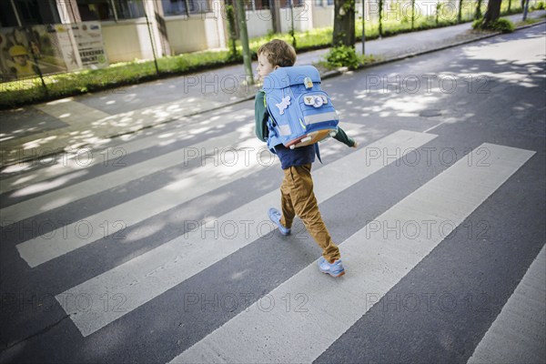Symbol photo on the subject of schoolchildren in road traffic A six-year-old boy walks across the