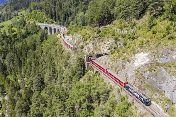 Drone shot of train between Schmittentobel-viadukt and the Landwasserviadukt, near Filisur, red