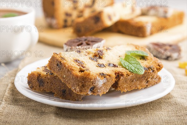 Homemade cake with raisins, dried persimmon and a cup of hot chocolate on a gray concrete