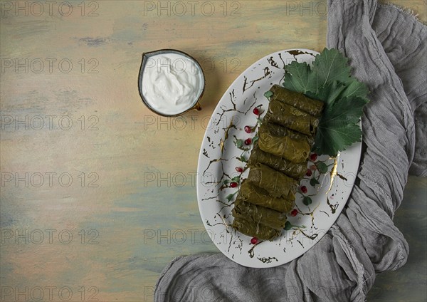 Dolma, cabbage rolls in grape leaves, Traditional Armenian dish, with white sauce, top view,