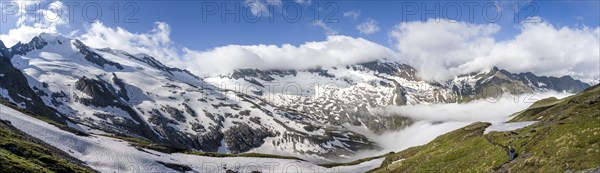 Mountaineer on hiking trail, mountain panorama with high fog in the valley, summit Hochfeiler,