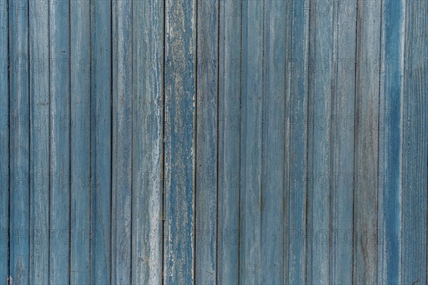 Garage door boards stained blue with worn paint. Brittany France