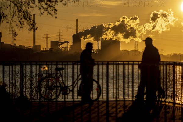 Rhine promenade in Duisburg-Wanheim, sunset, view of the Rhine and Hüttenwerke Krupp Mannesmann,