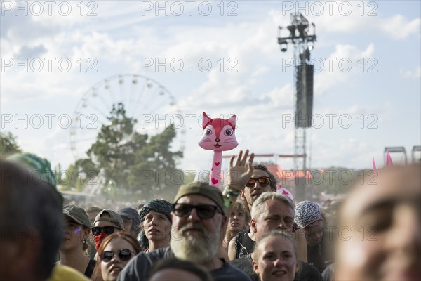 An inflatable cat looks out between festival visitors at the Highfield Festival on Saturday,