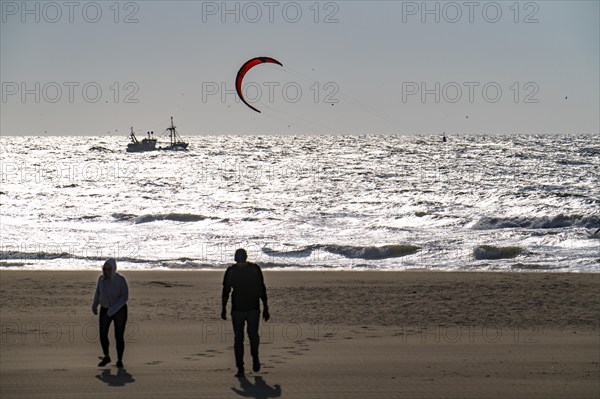Kitesurfers and shrimp boats off the coast of Scheveningen, walkers on the beach, The Hague,