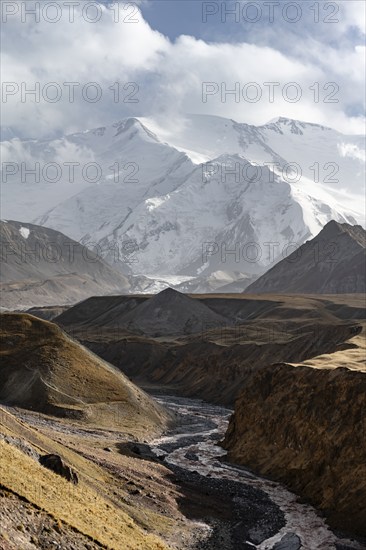 Achik Tash river, Achik Tash valley, behind glaciated and snow-covered mountain peak Pik Lenin,