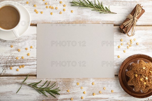 Gray paper sheet mockup with cup of coffee and cake on white wooden background. Blank, top view,