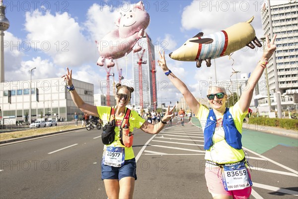 Runners with balloons in the shape of a pig and a dog on Karl-Marx-Allee at the 50th BMW Berlin