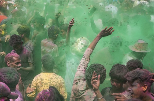Revellers dancing in the beat of music as they celebrate Holi on a street, the Hindu spring