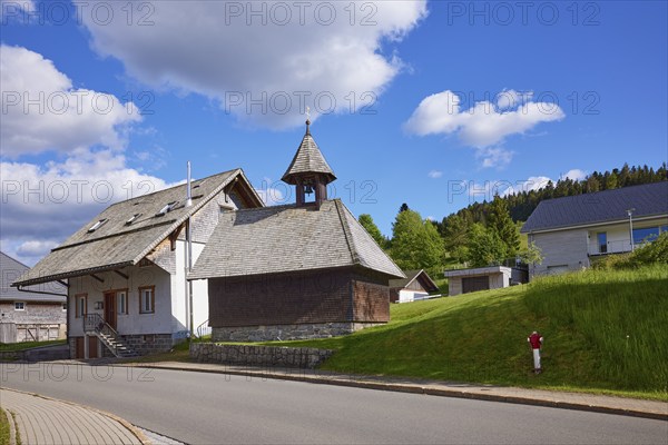 Chapel Unterlehen with road under blue sky with cumulus clouds in Bernau im Black Forest, Black