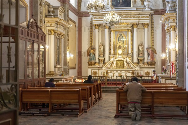 Oaxaca, Mexico, A man kneels in prayer in a Catholic church, Central America