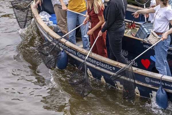 Plastic Whale boat in a canal in Amsterdam, passengers fish plastic waste out of the canals, tour