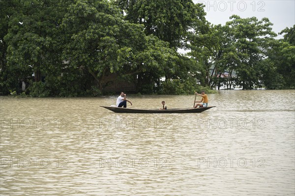 Morigaon, India. 4 July 2024. People travel in a boat to cross a flooded area, in a flood affected