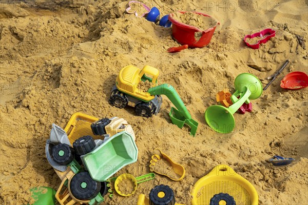 Sandpit, on a children's playground, sandpit with various plastic toys, excavator, shovels, moulds