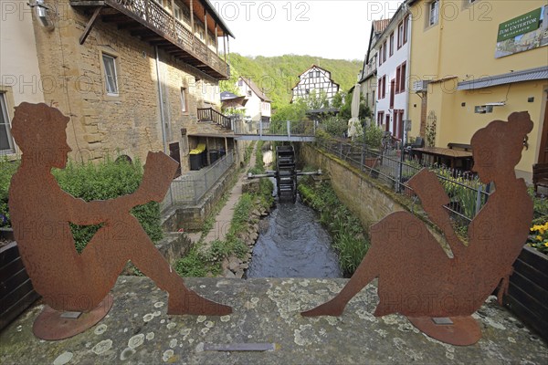 Two rusty figures reading a book on the bridge over the Gießen stream, sitting, rusty, brown, boy,