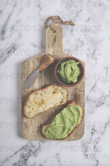 Ciabatta with avocado pasta, breakfast, on a chopping board, top view, homemade, no people