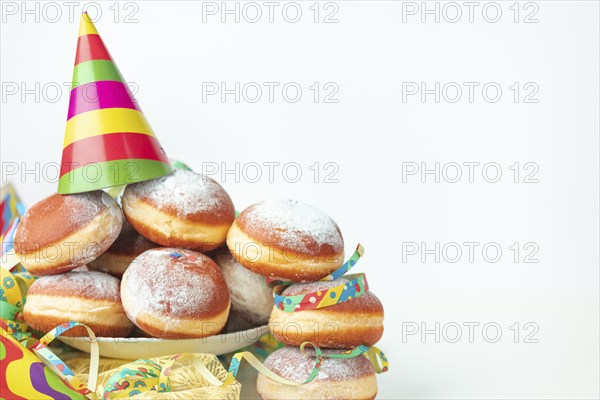 Colourful streamers, paper hats and doughnuts, carnival, copy room, white background