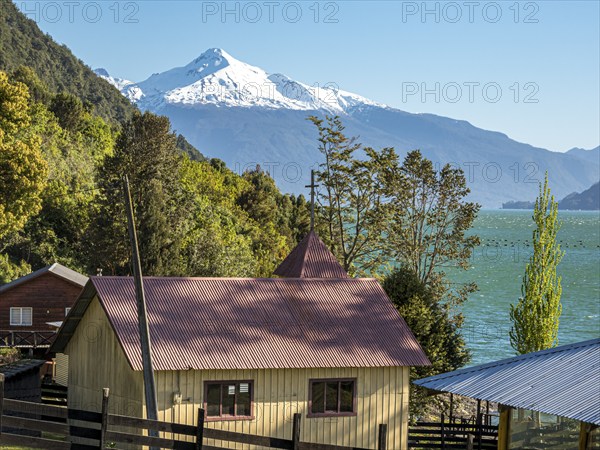 Farm and chapel at the Reloncavi fjord southeast of Puerto Montt, volcano Yates, Chile, South
