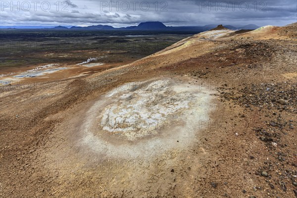 Hot springs and geothermal area in front of mountain landscape in summer, cloudy, sulphur qu,