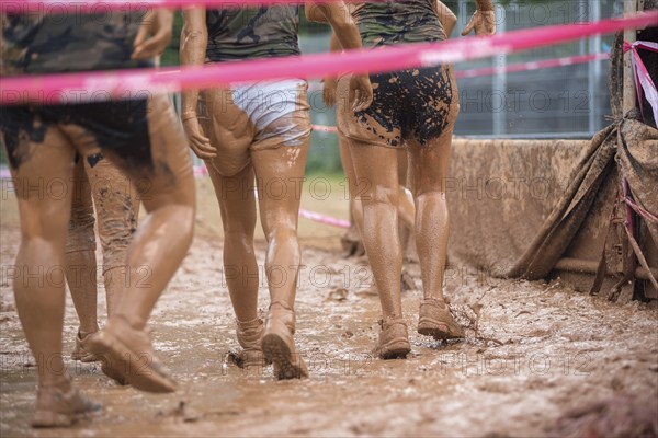 Group of participants in a muddy outdoor obstacle course