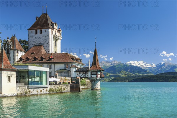 Oberhofen Castle on Lake Thun with a view of the mountains with the snow-covered Blüemlisalp,