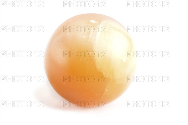 Orange onyx sphere isolated on white background, close up