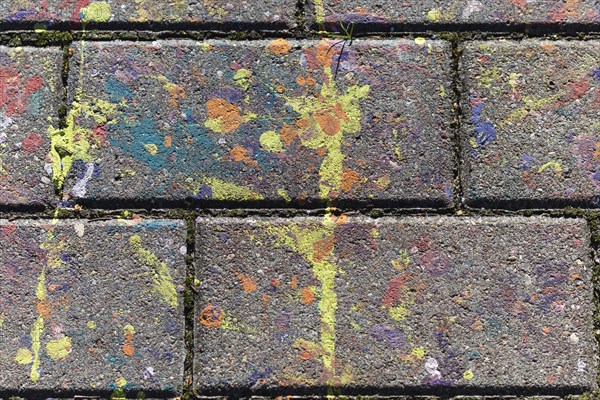 Multicolored spots of paint on a concrete slab