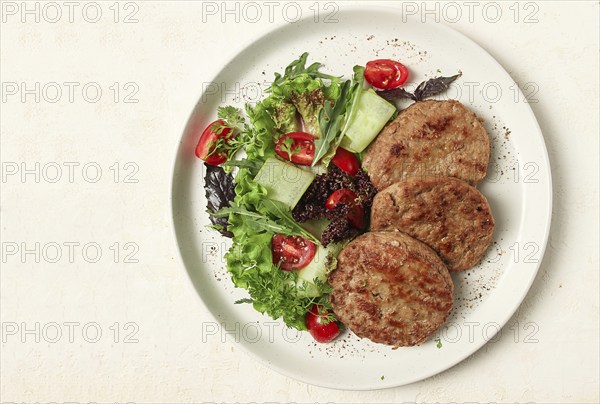 Fried cutlets, minced beef, with vegetable salad, top view, no people