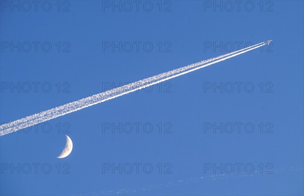 Aeroplane in the sky, vapour trail, crescent moon, waxing crescent moon, over Frankfurt am Main