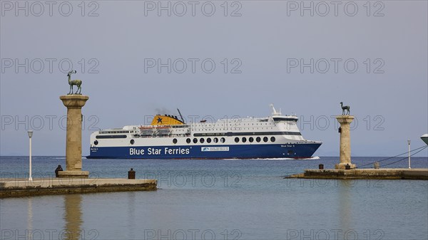 Ferry boat sailing between columns with statues on blue sea, Deer statue, Deer statue, Mandraki