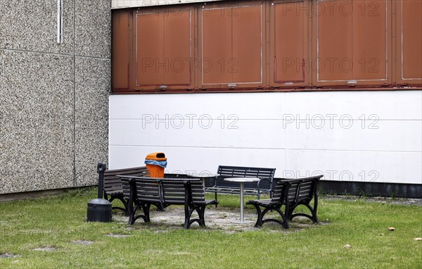 Benches, a table and a wastepaper basket in an outdoor break area on a factory site, Berlin,