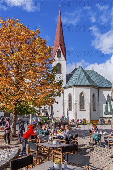 Village square with pilgrimage church of St. Oswald in autumn, Seefeld in Tyrol, Seefeld Plateau,