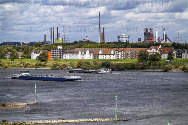Cargo ship on the Rhine near Duisburg-Laar, houses on Deichstraße, industrial backdrop of the