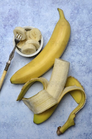 Opened banana and banana slices in peel